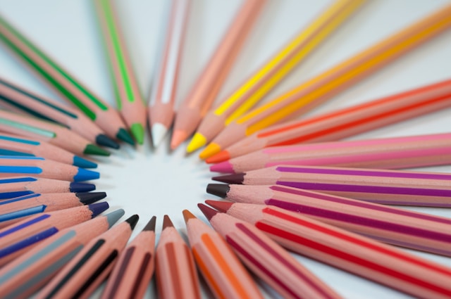 crayons de couleurs positionnés en rond, la mine vers l'intérieur, classés par dégradés de couleurs.